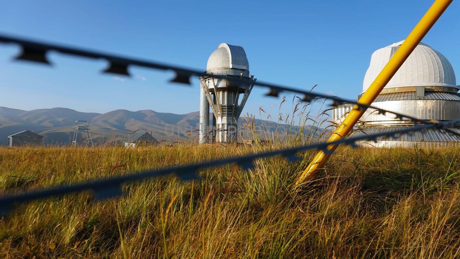 A large observatory is protected by a barbed fence by Passcal