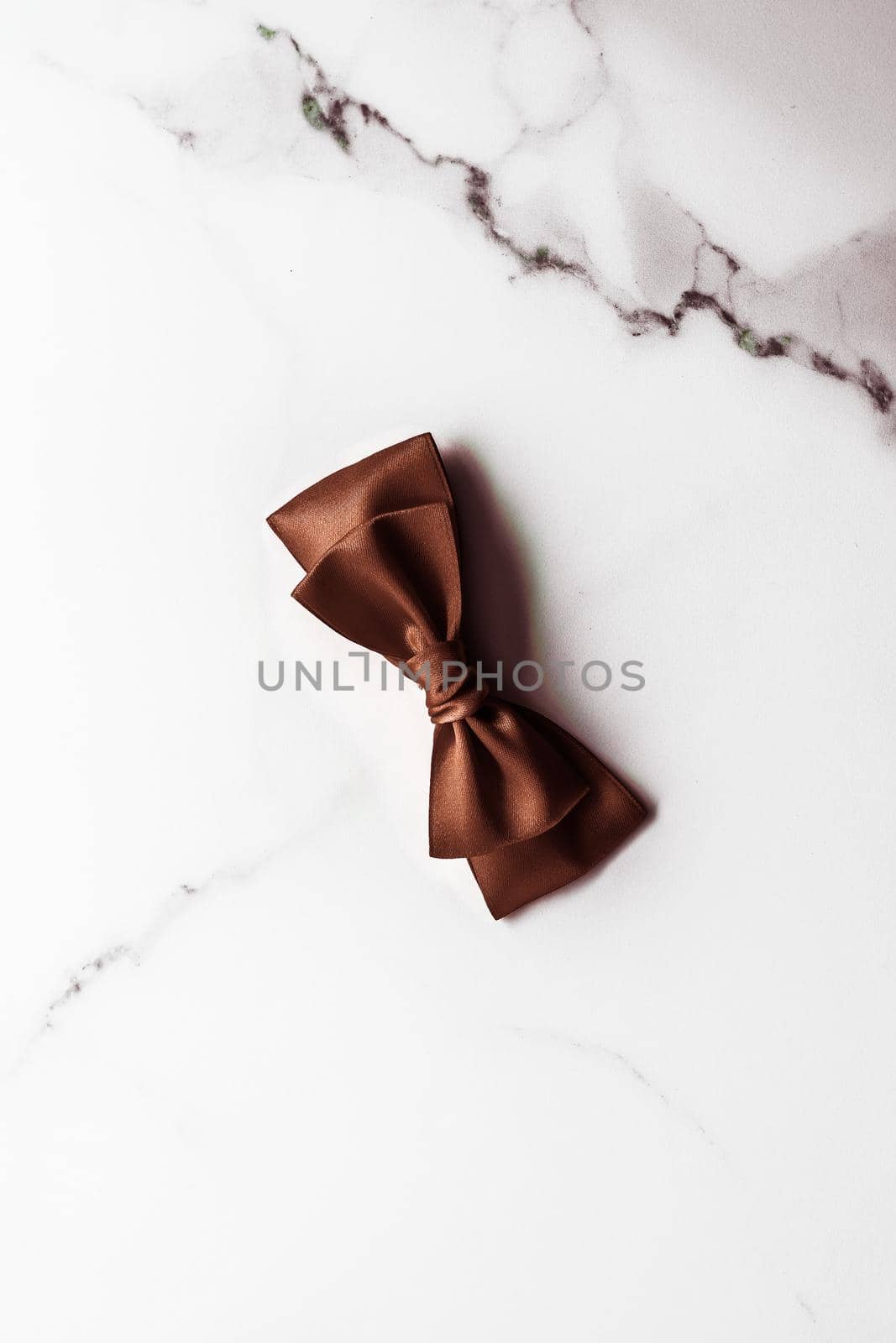 Holiday gift, decoration and sale promotion concept - Chocolate brown silk ribbon on marble background, flatlay