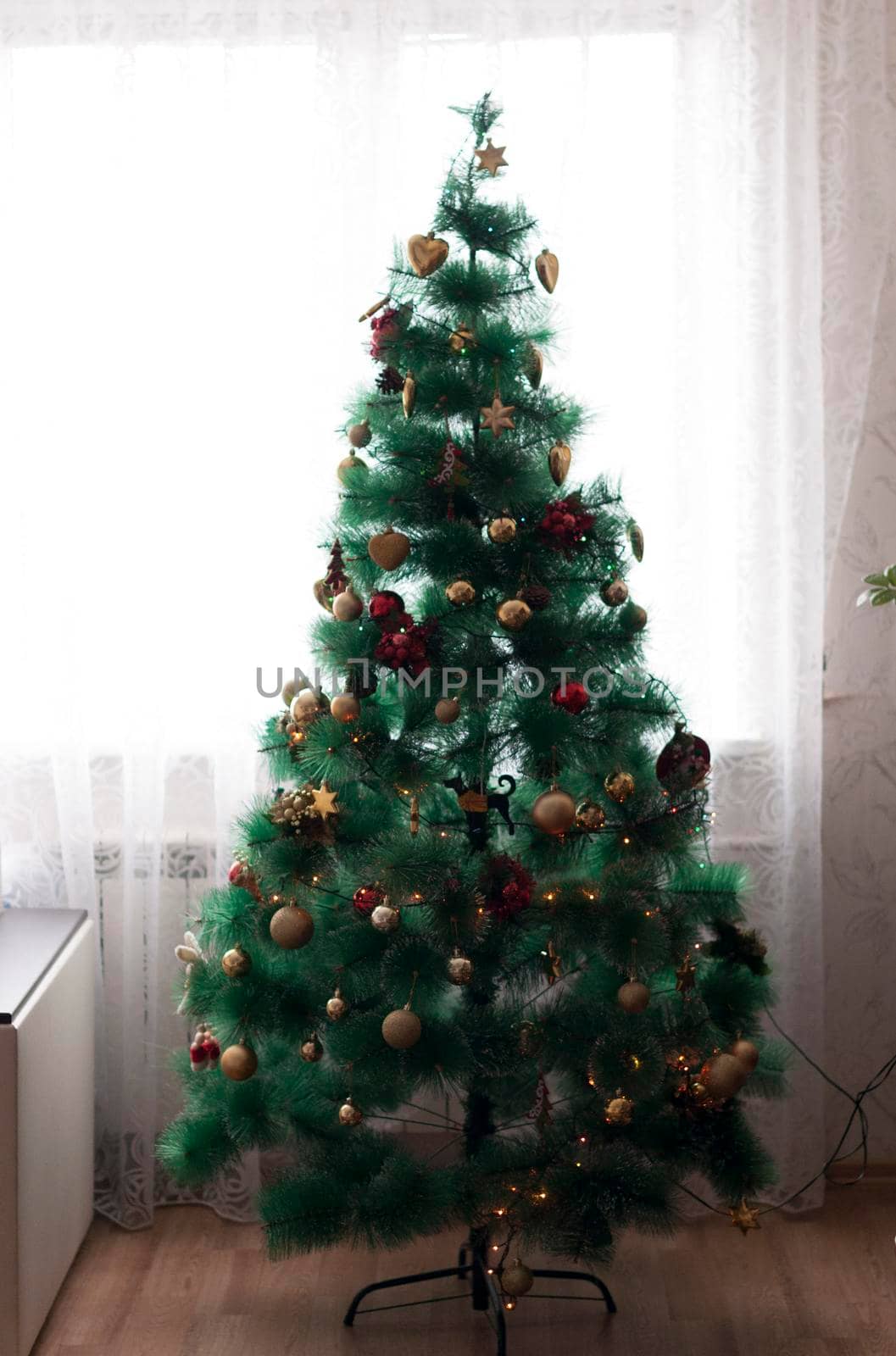 Festively Decorated Outdoor Christmas tree on blurred sparkling fairy background. High quality photo
