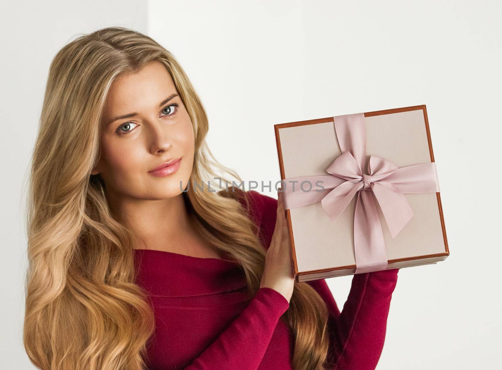 Holiday present for birthday, baby shower, wedding or luxury beauty box subscription delivery, happy woman holding a wrapped pink gift on white background