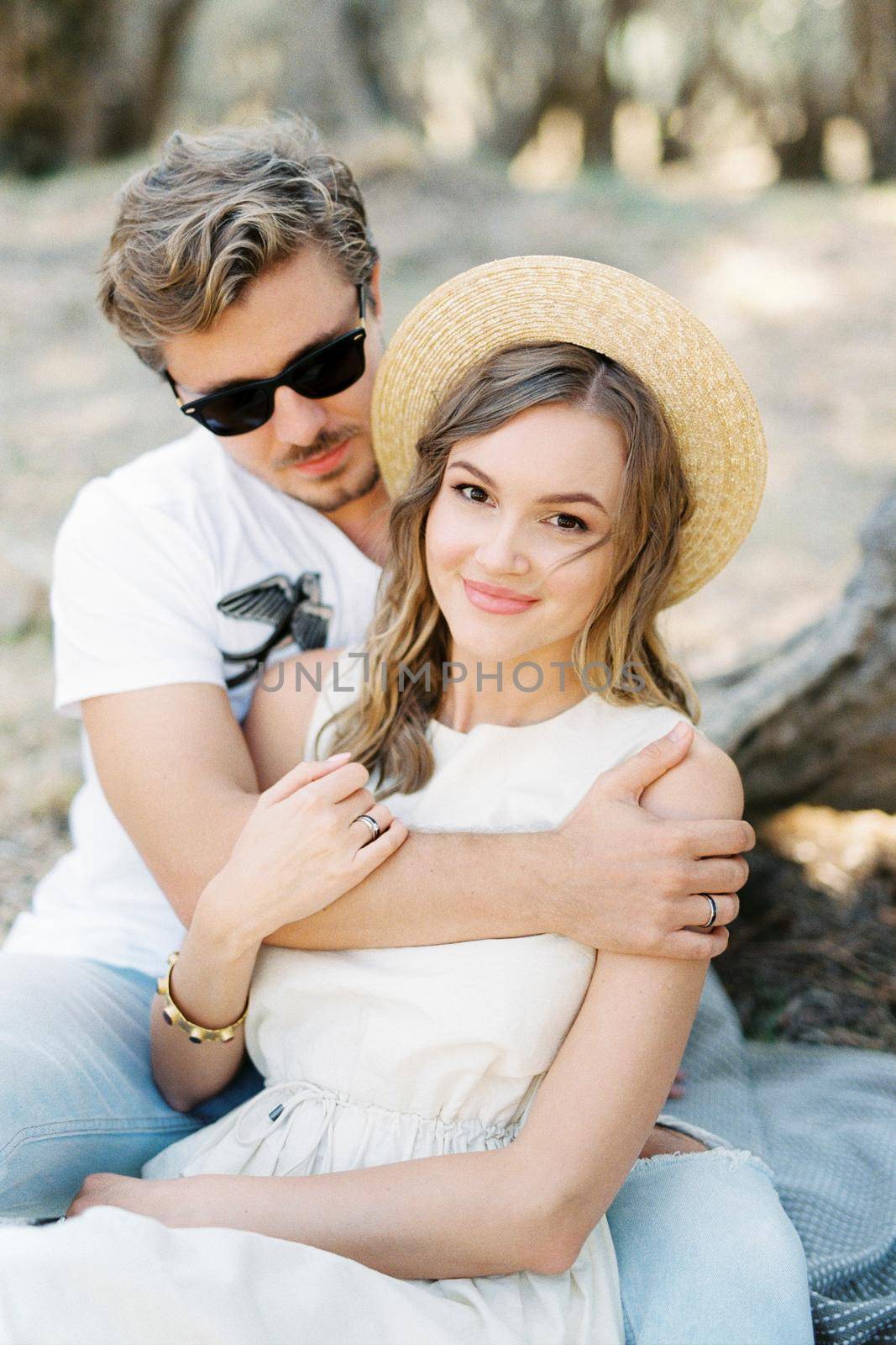 Man hugging woman in straw hat. High quality photo