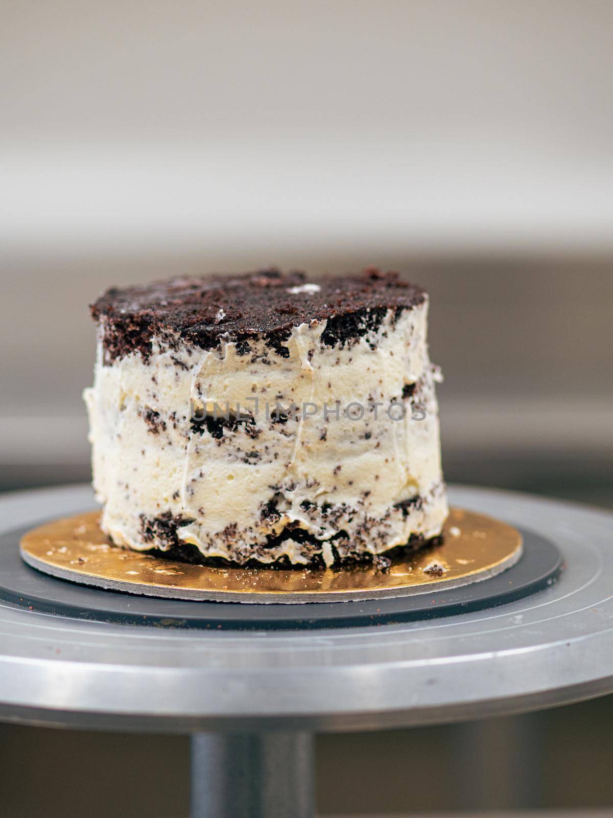 professional baker decorating a chocolate and cream cake with salty caramel