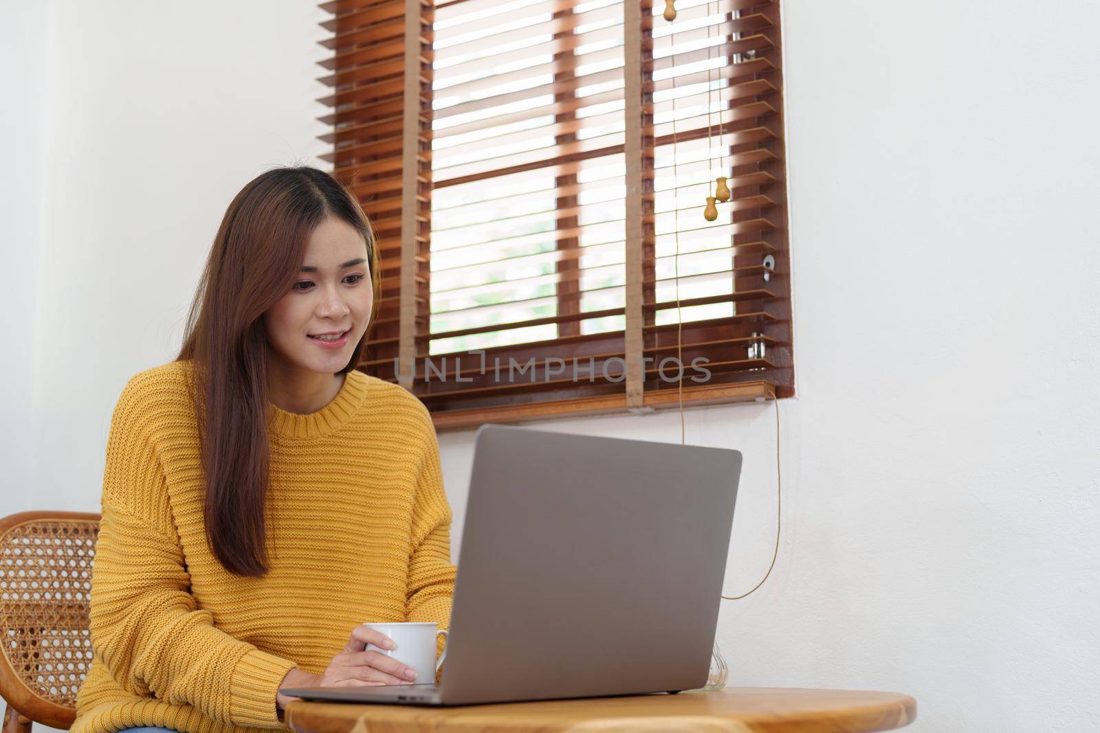 Portrait of an Asian businesswoman or business owner taking a coffee break while working in the office.