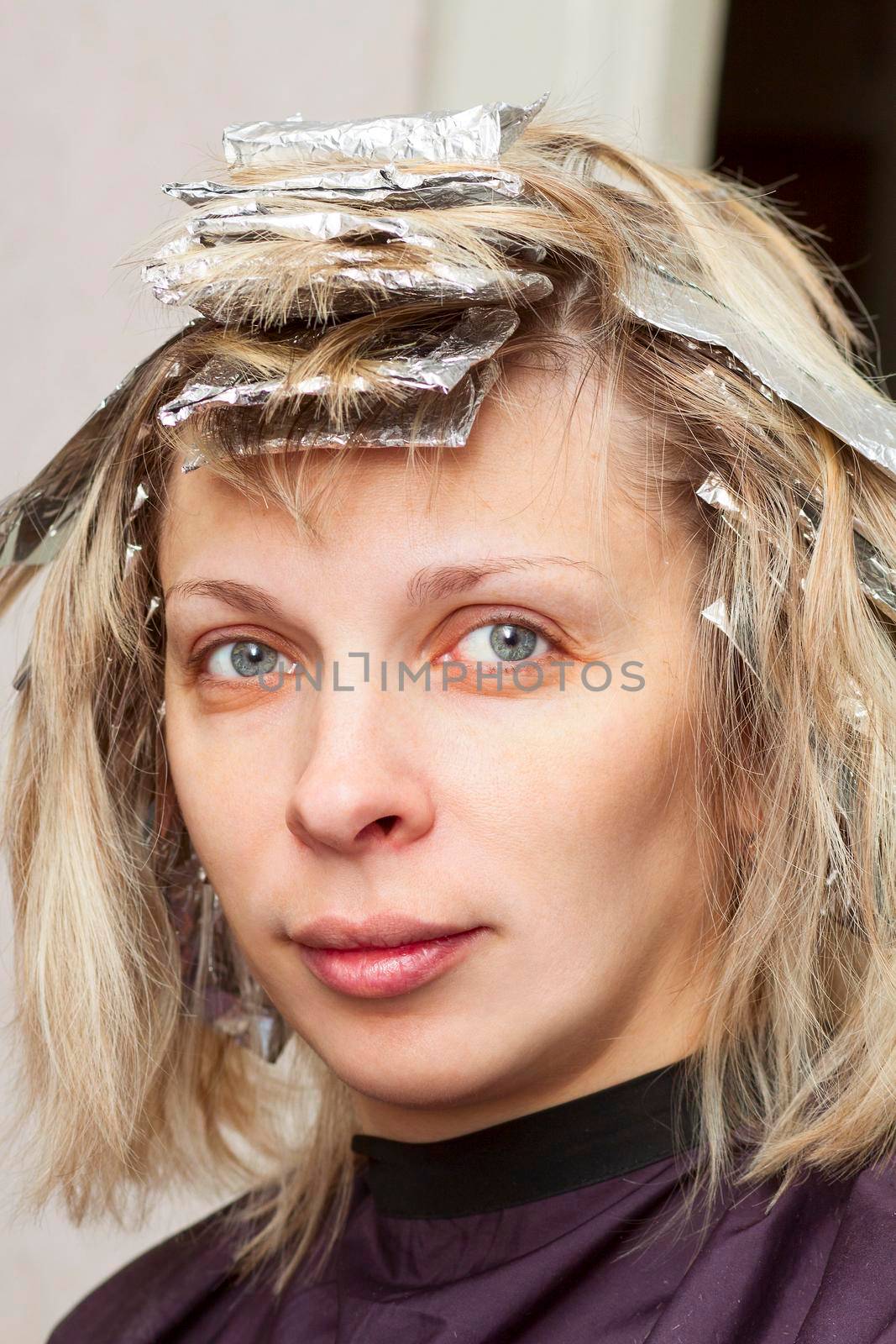 woman with coloring foil on her hair in salon