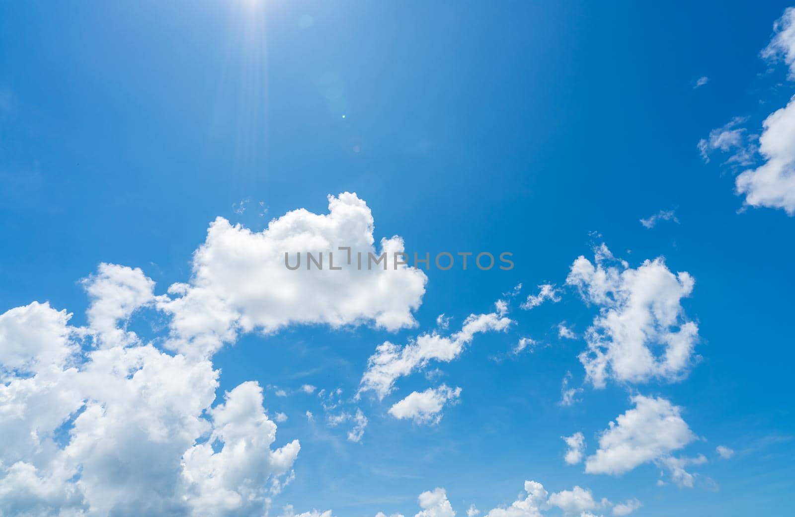 Blue sky and white clouds with sunlight on sunny day. World ozone day concept. Blue sky background for international day for the preservation of the ozone layer. Cloudscape. Hot weather in summer. by Fahroni