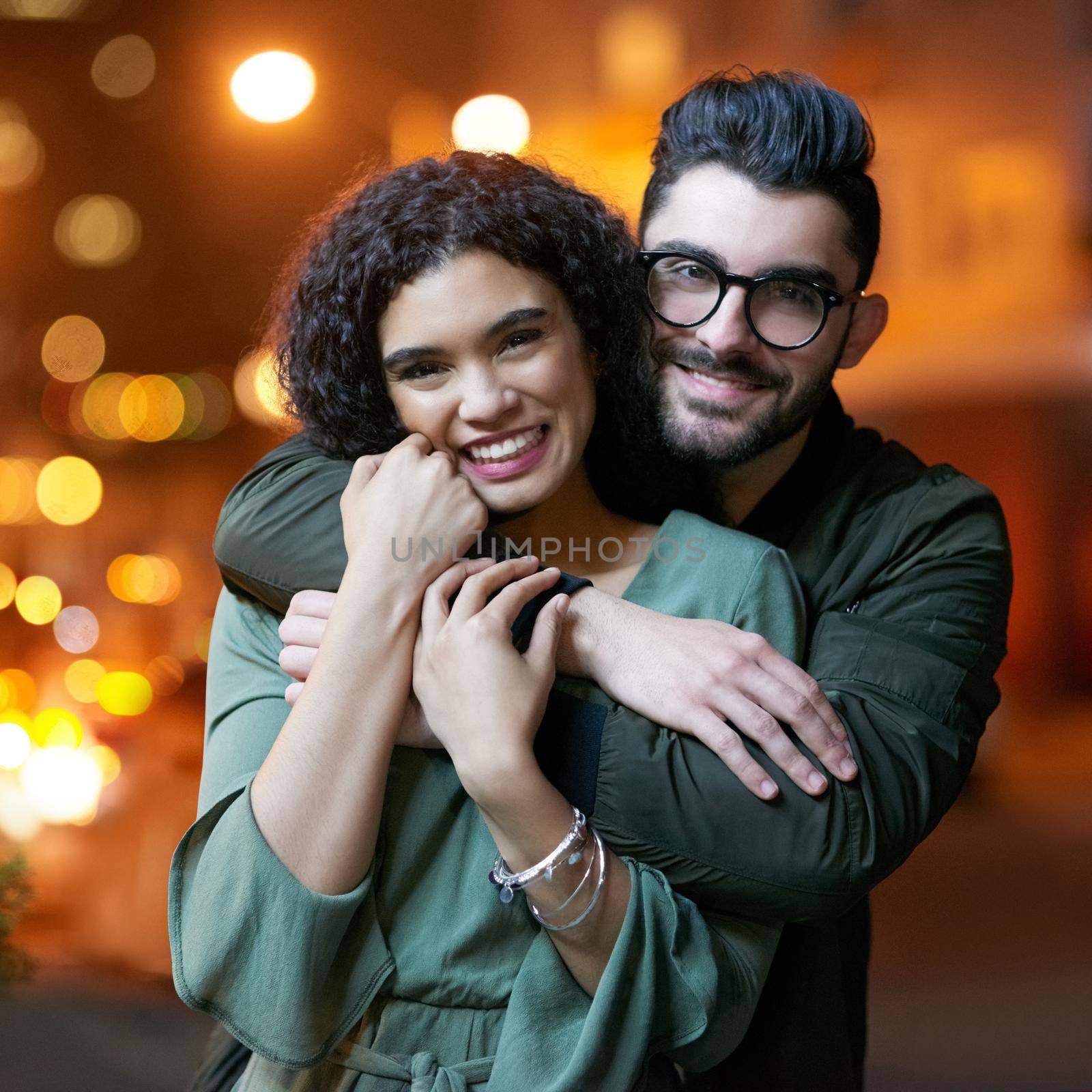 Shes my one and only. Portrait of a happy young couple outdoors at night. by YuriArcurs