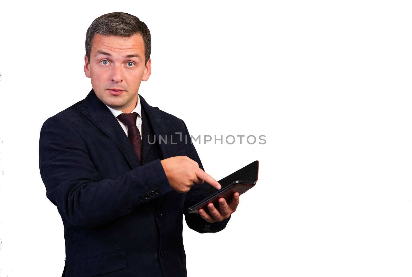 The man, dumbfounded by the news, points to the gadget with his hand. Man on a white isolated background.