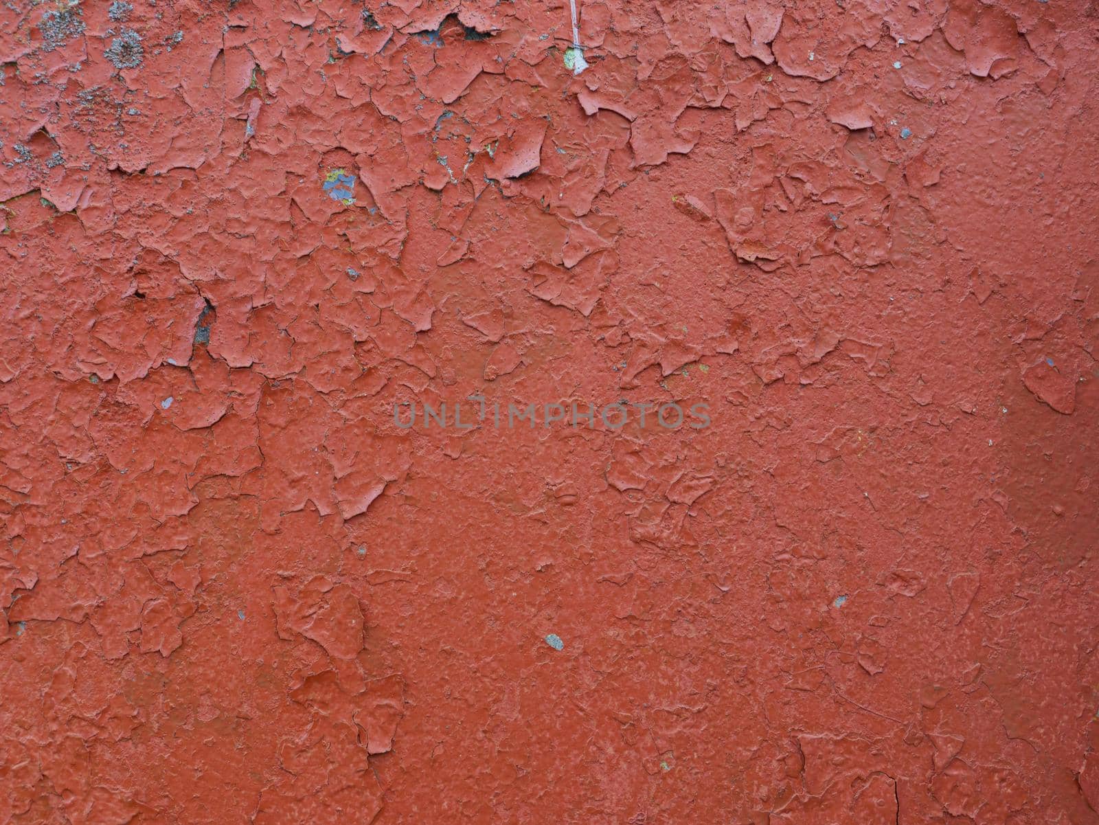 Old peeling red paint on an old wall. red paint texture on wall background.