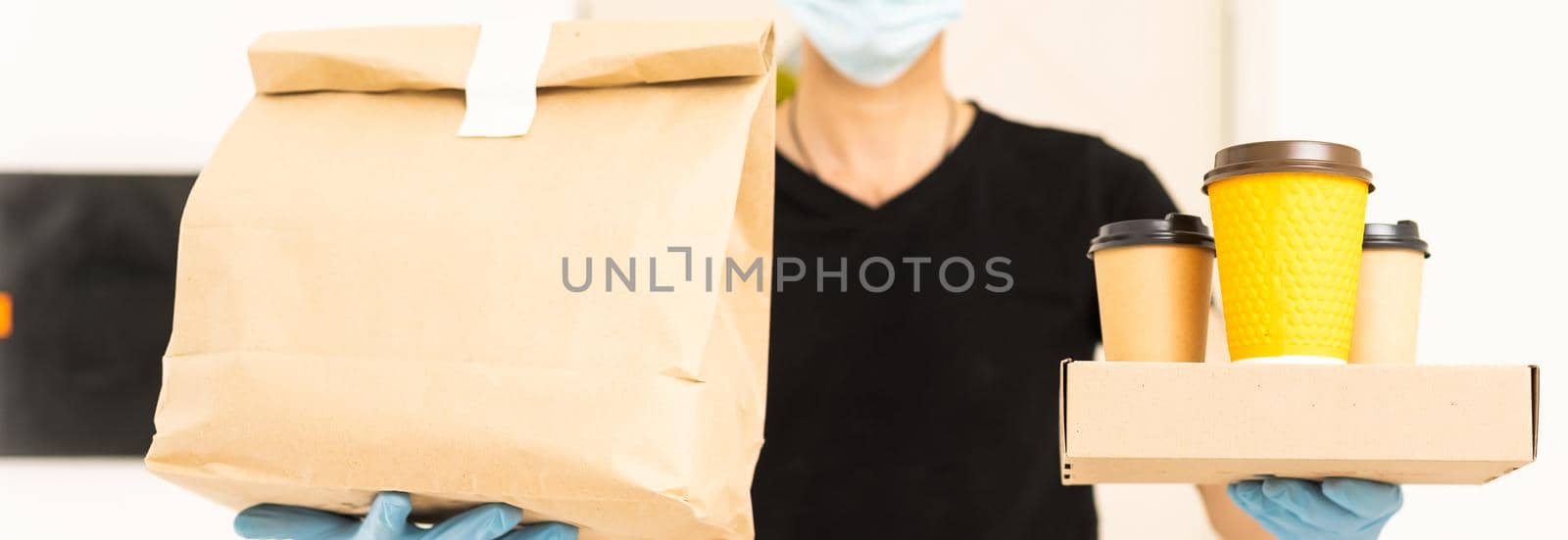 Delivery man holding cardboard boxes in medical rubber gloves and mask. copy space. Fast and free Delivery. Online shopping and Express delivery. Quarantine.