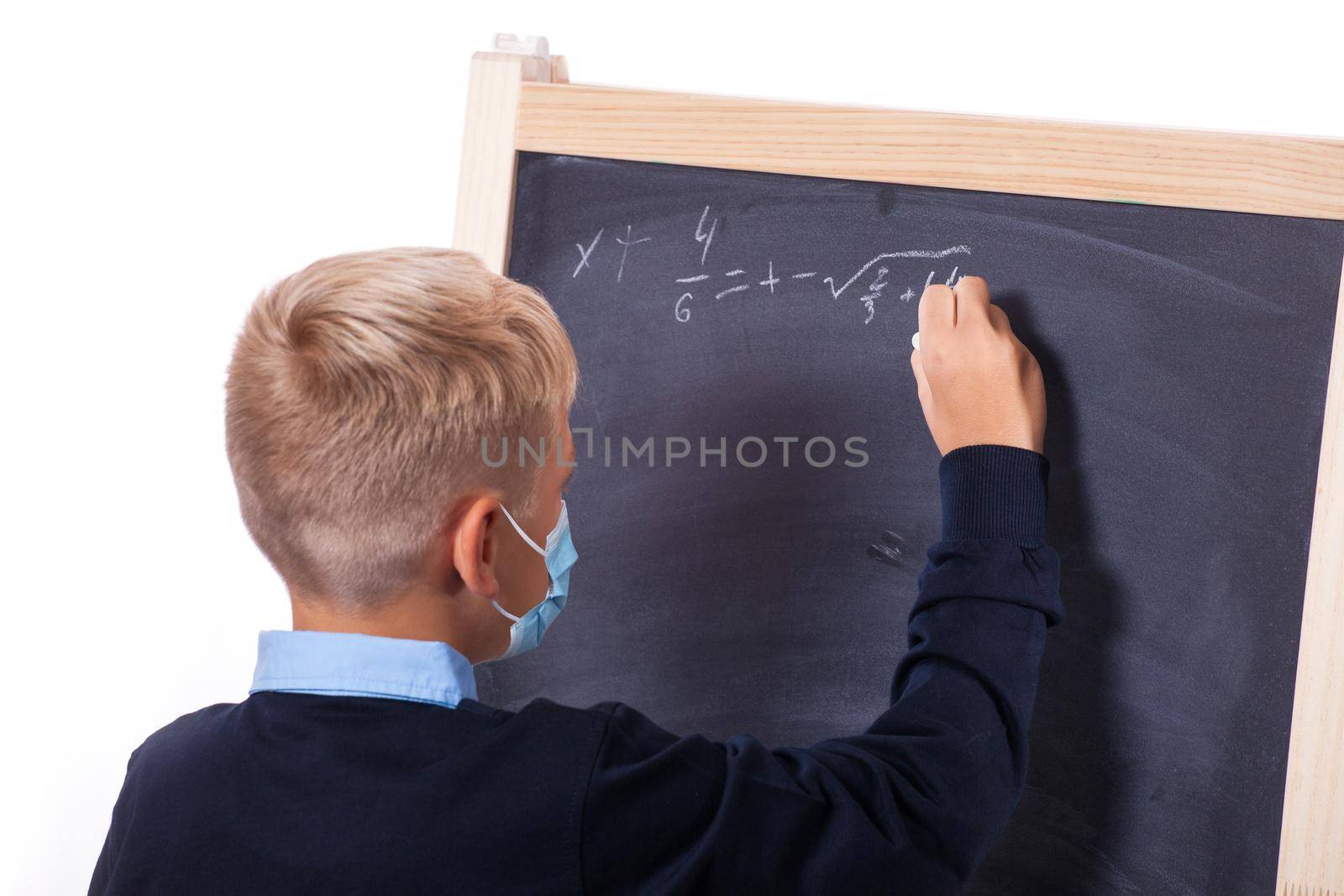 Young boy with protection mask against corona virus at school. by Taut