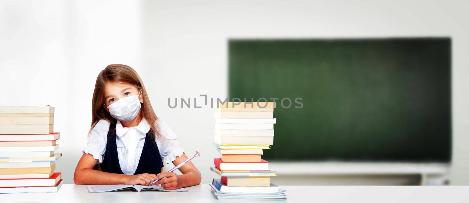 Young girl with protection mask against corona virus at school. by Taut