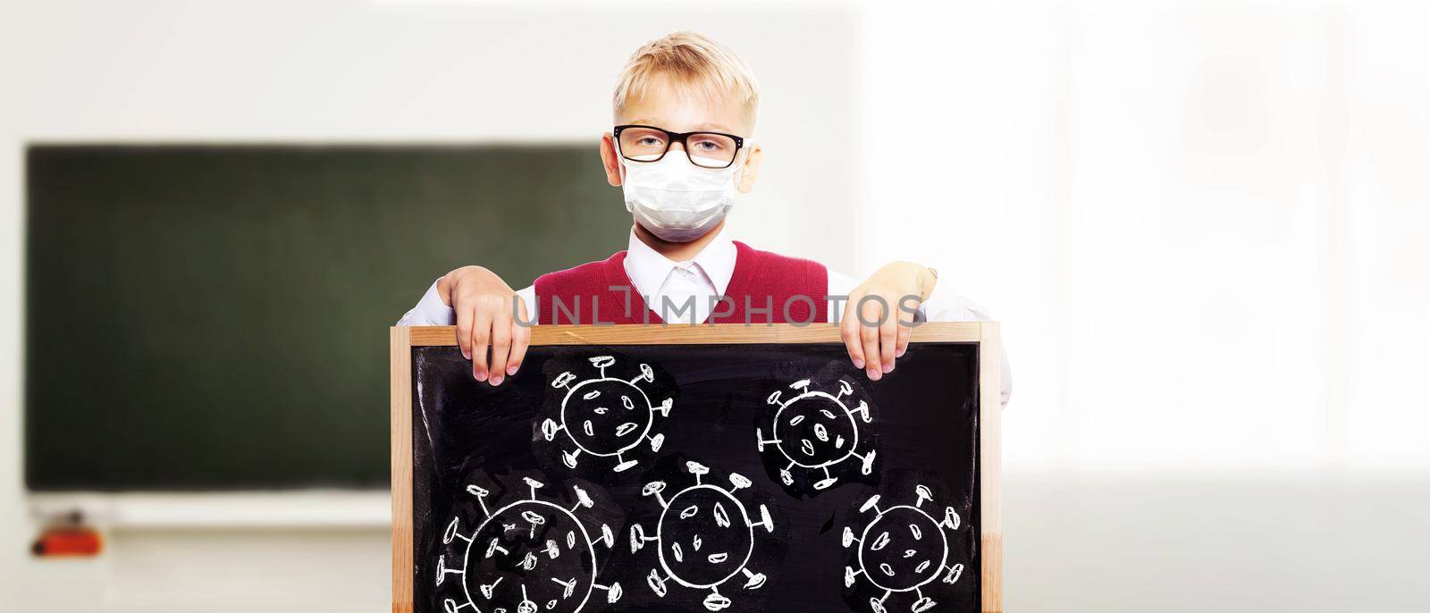 Young boy with protection mask against corona virus at school. by Taut