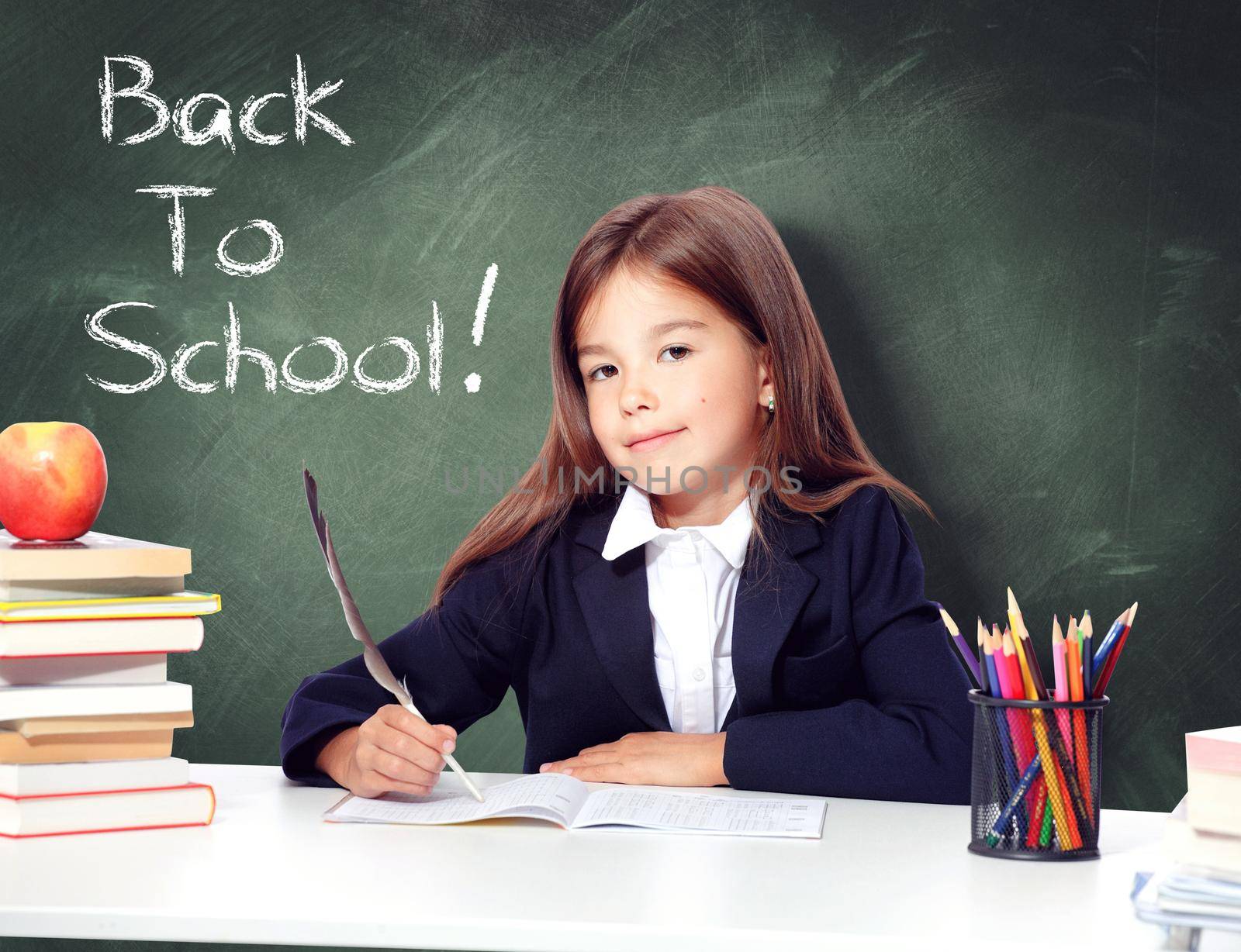 Happy and cute teen school girl writes in a book or notebook by Taut