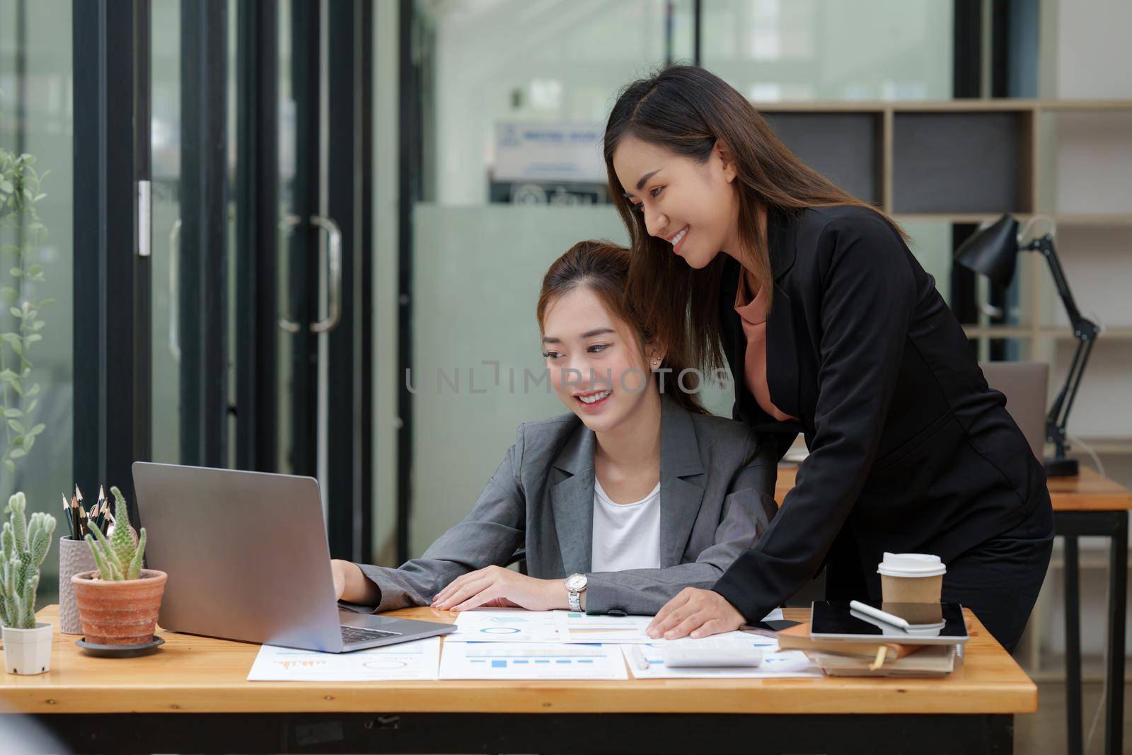 Two Asian Business woman working together by laptop at office.