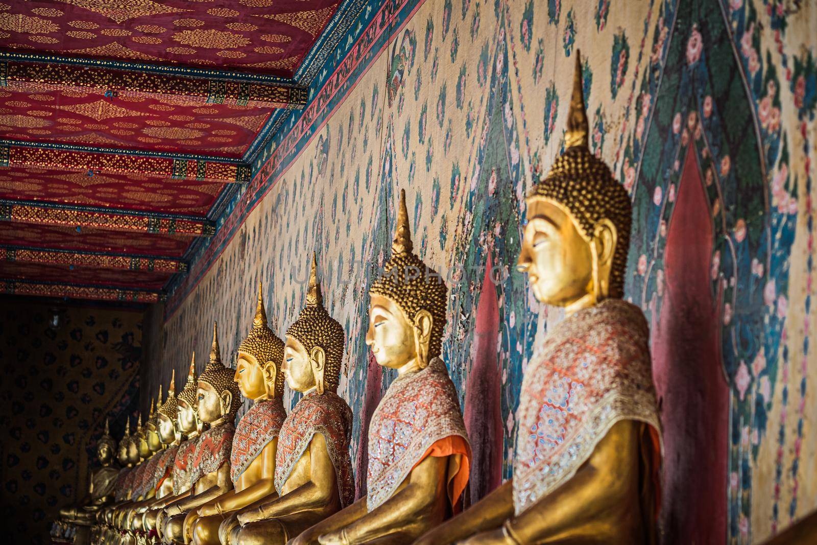 Row of brass gold Buddha statue image in meditation posture