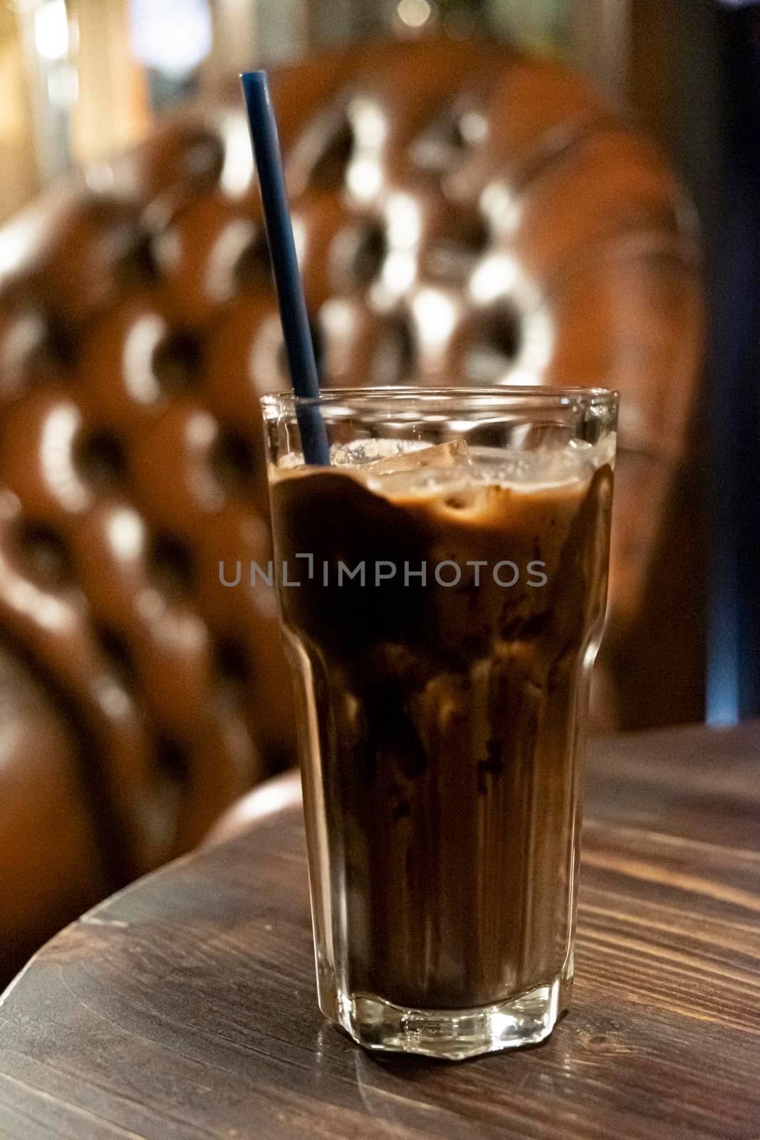 iced latte cocoa chocolate in a  tall glass. cold summer drink background