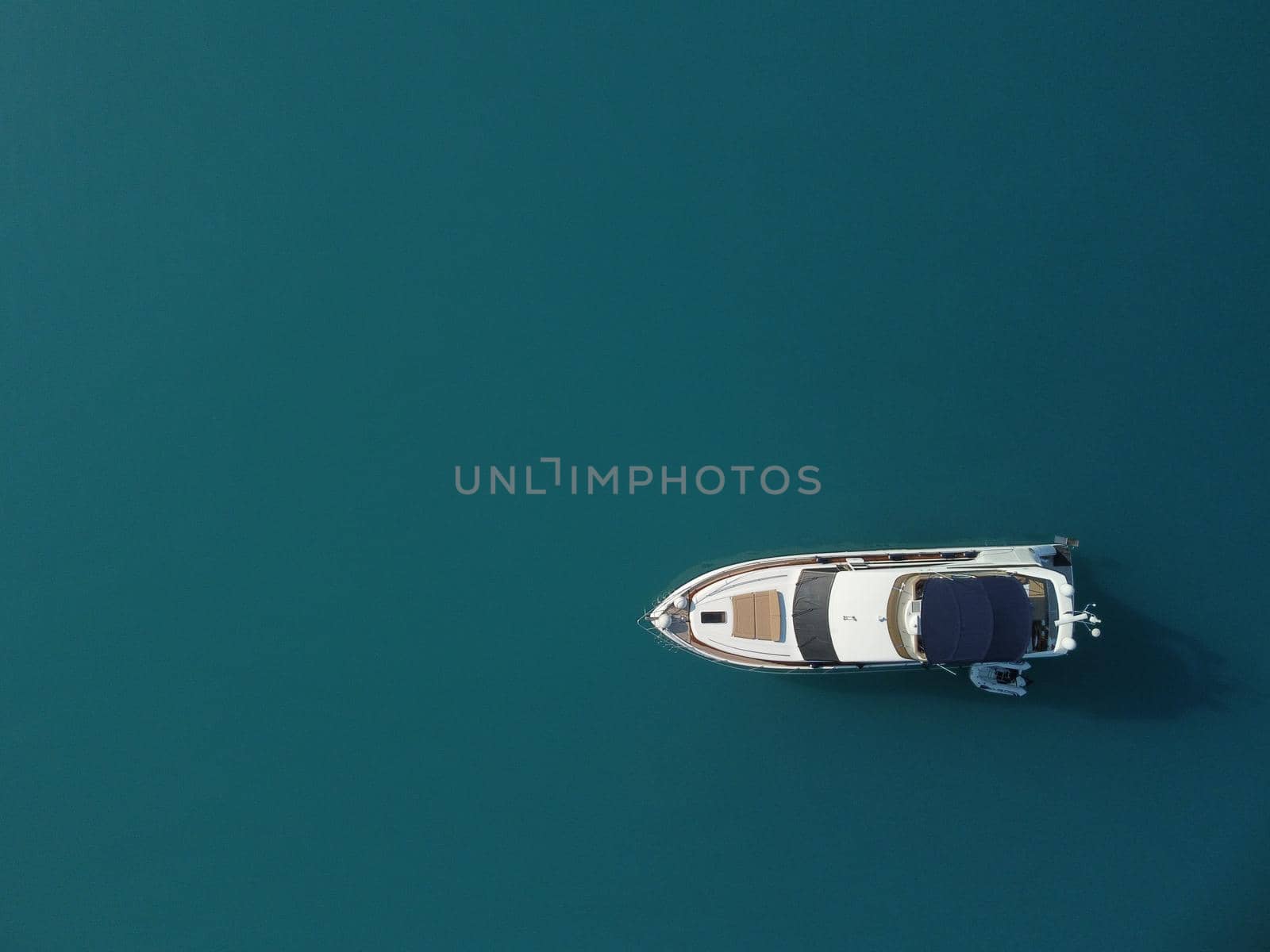 Aerial boat race. Luxury cruise trip. View from above of white boat on deep blue water. Aerial view of rich yacht sailing sea. Motor boat racing wave. Summer journey on luxury ship