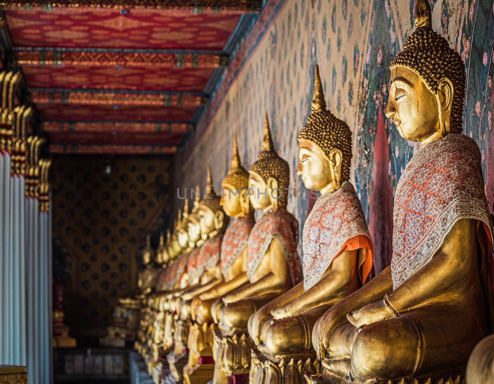 Row of brass gold Buddha statue image in meditation posture