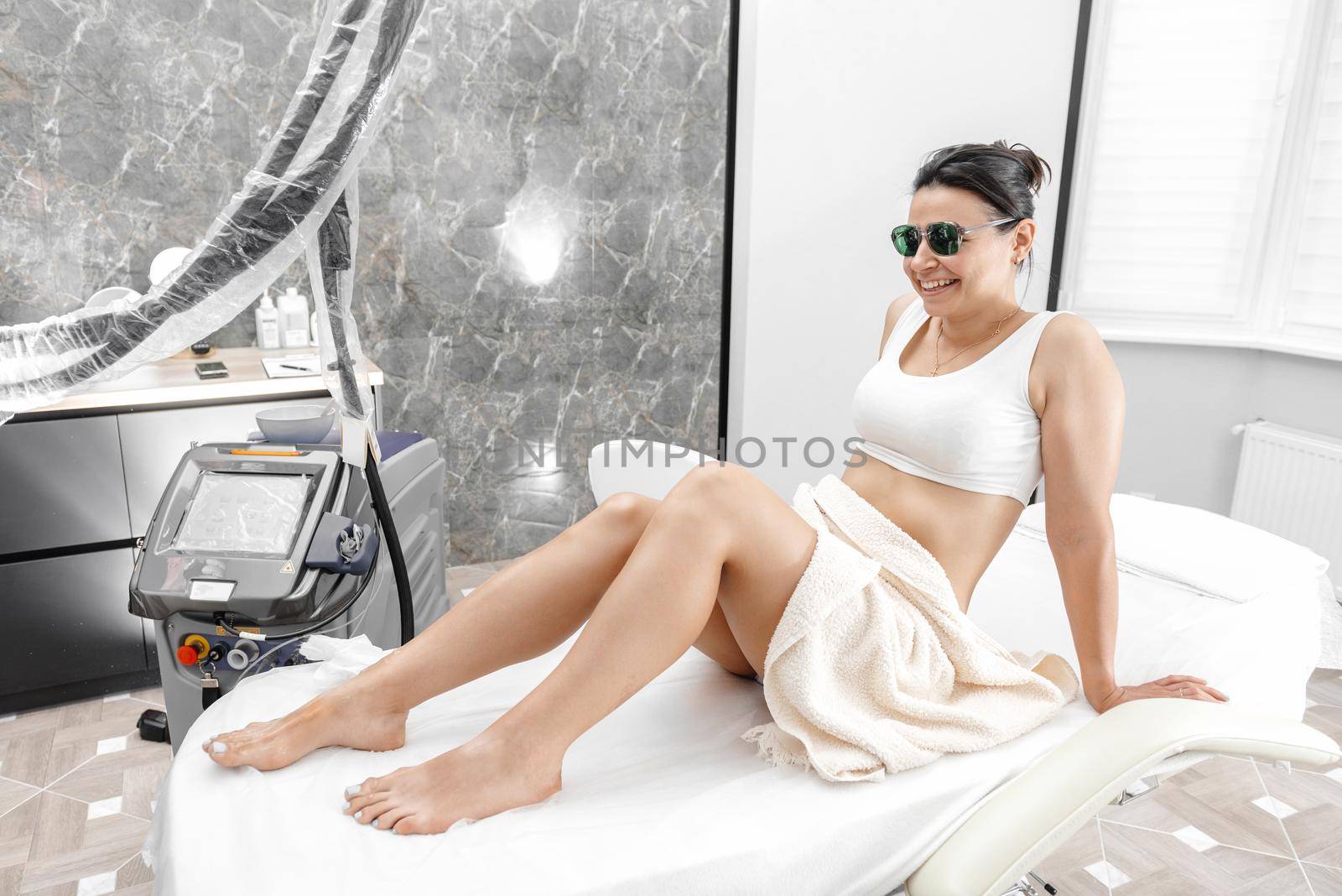 Laser hair removal and cosmetology in a beauty salon. Hair removal procedure. cosmetology, spa and hair removal concept. Beautiful woman removes hair on her legs by gulyaevstudio