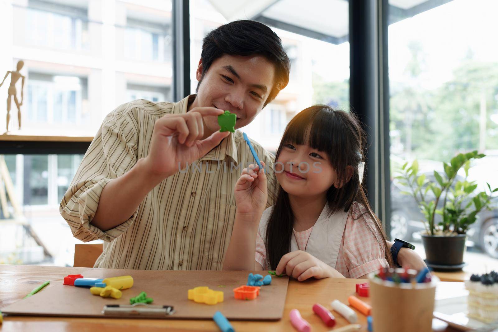 Adorable little girl and father playing with colorful plasticine. Handmade skills training.