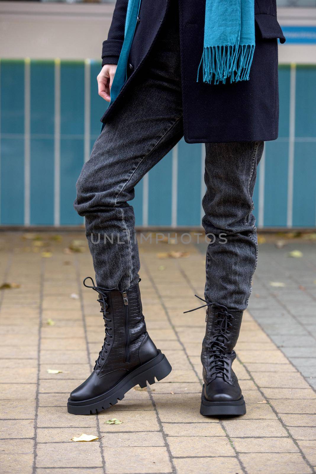 Slender female feets in military boots. street photo. woman wearing black jeans