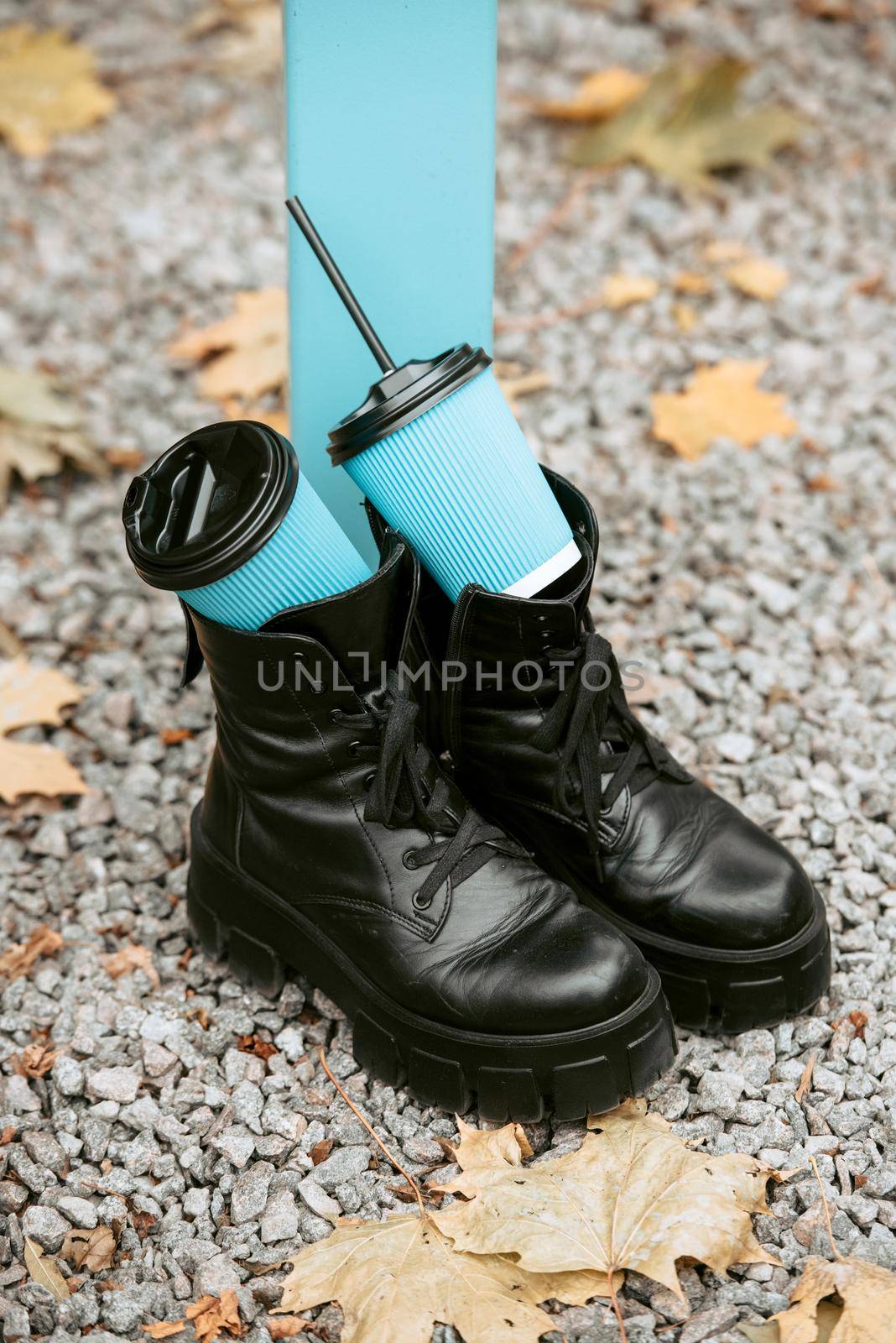 Slender female feets in military boots. street photo. Two blue paper coffe cups by Ashtray25