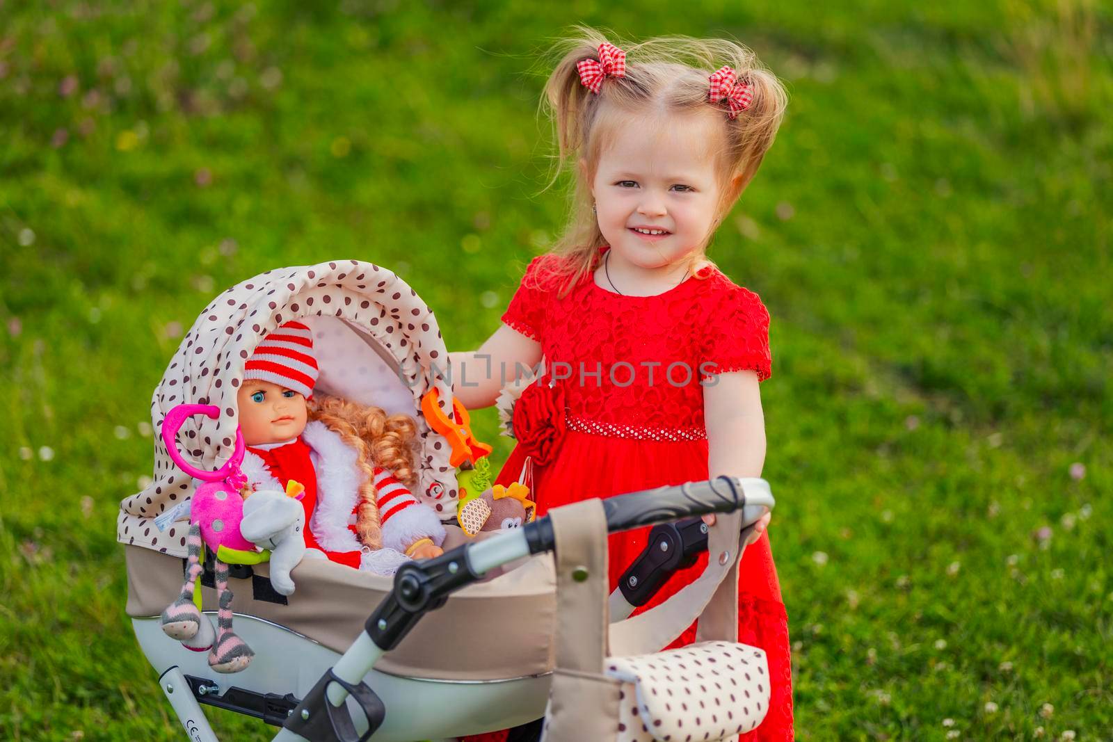 girl playing with a doll in a stroller in nature