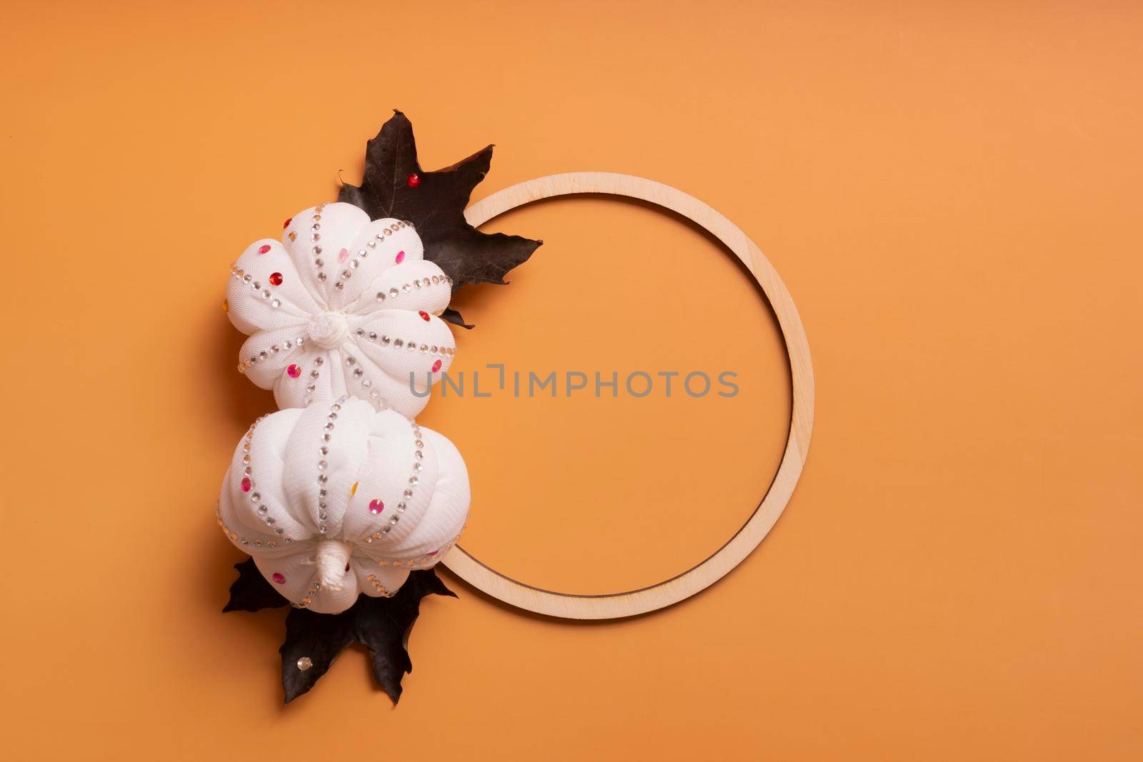 White decorative textile pumpkins with shiny stones and wooden frame for your text. Autumn harvest and thanksgiving day concept.