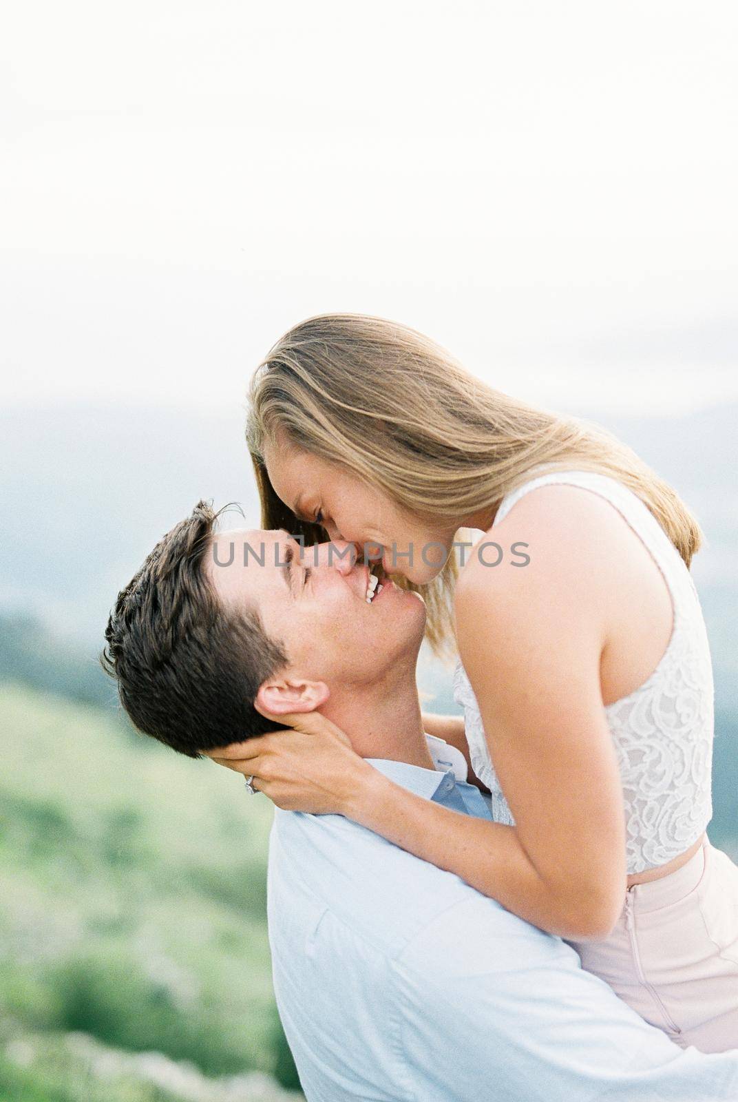 Man holds woman in his arms and kisses her. Portrait. High quality photo