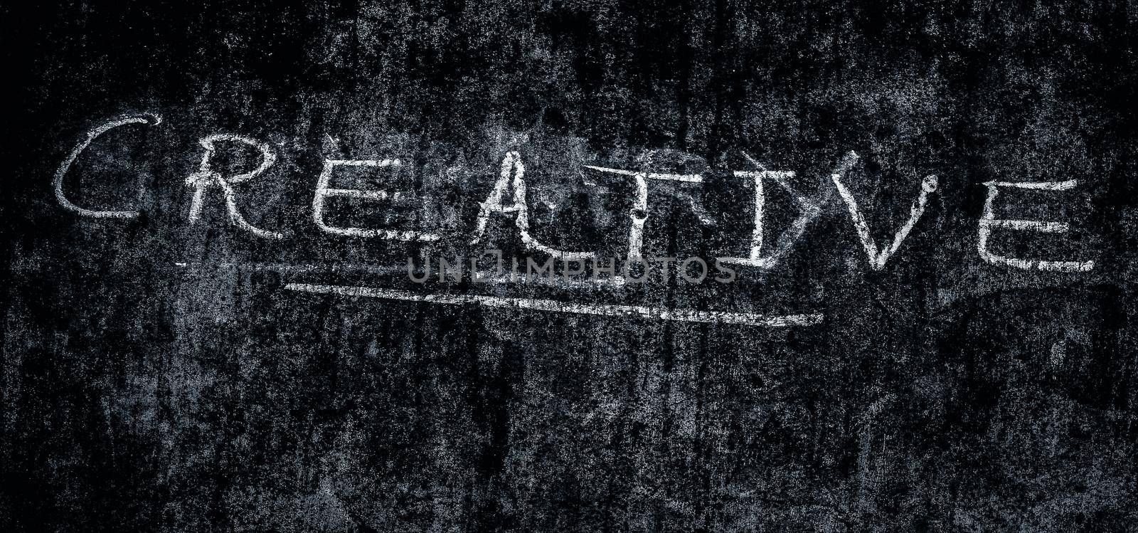 The creative word is written on a rough wall, close up shot, horizontal orientation.