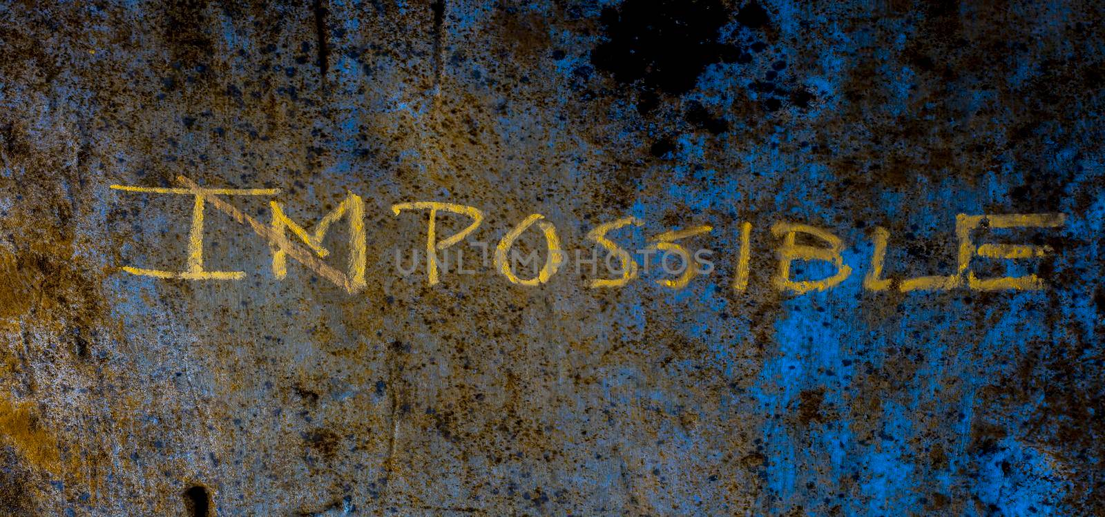 Creative and unique Possible written on a rough wall. Shot of impossible word written with a cross on Im making Possible. Think Different Concept.