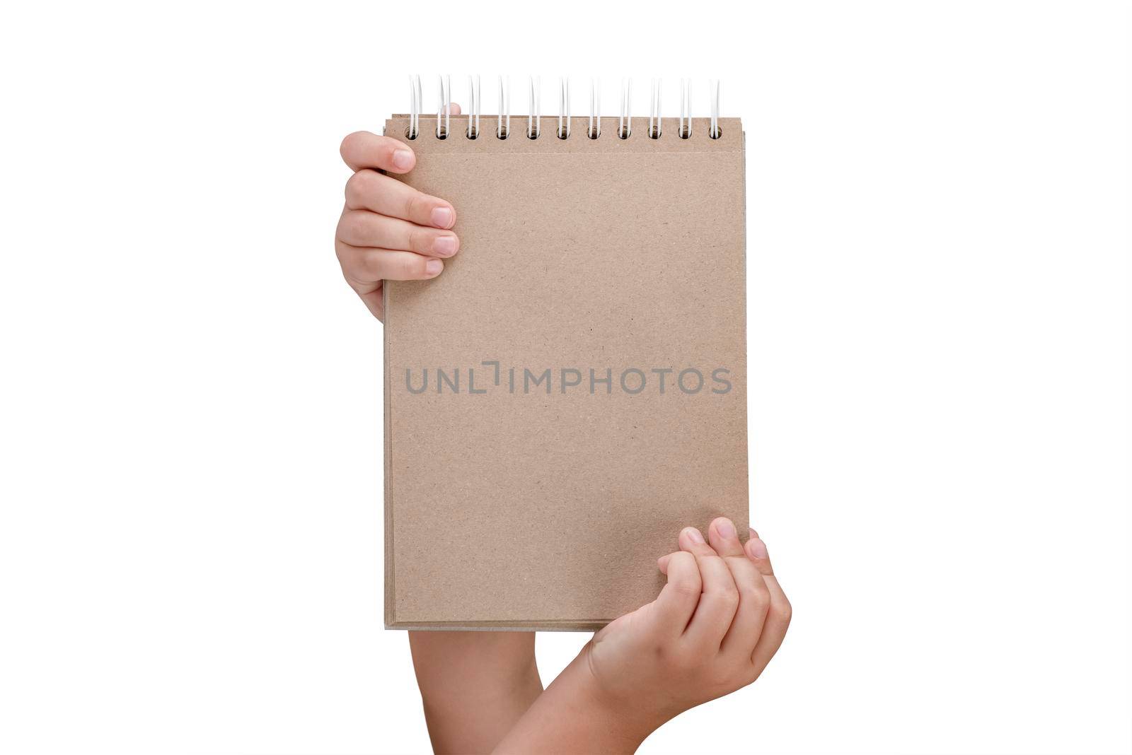 Notepad isolated on white background. Brown notepad made from recycled paper on a white background in the hands of a child.
