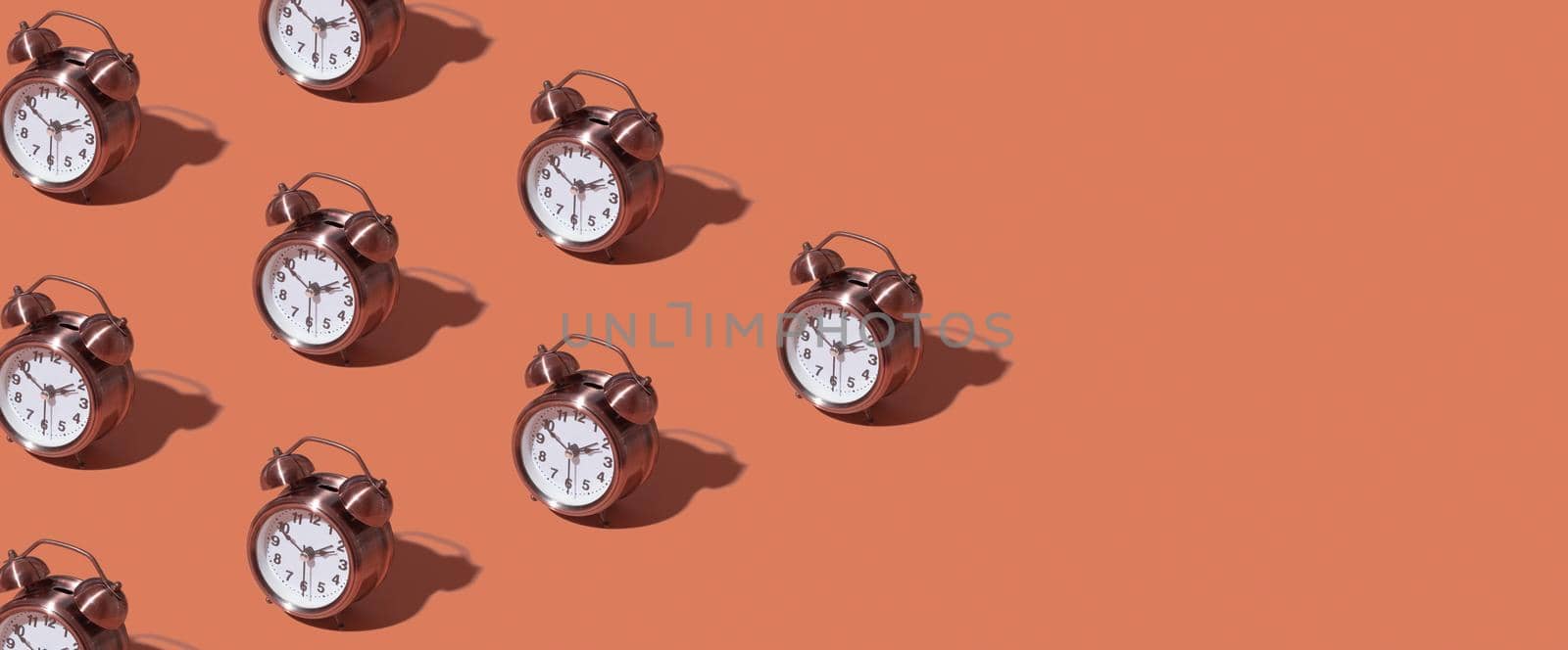 Pattern of an alarm clock on a colored background. Monochrome time concept. Banner format. by ssvimaliss