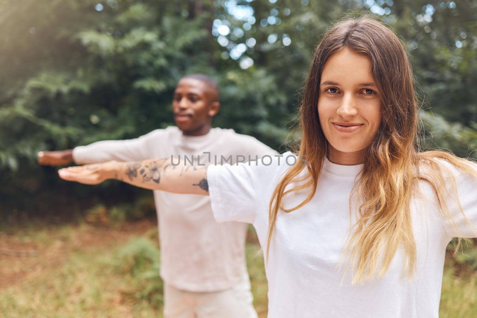 Fitness, zen and yoga couple exercise outdoors in park or forest together, bonding while living a healthy lifestyle. Interracial girlfriend and boyfriend training balance and posture while meditating.