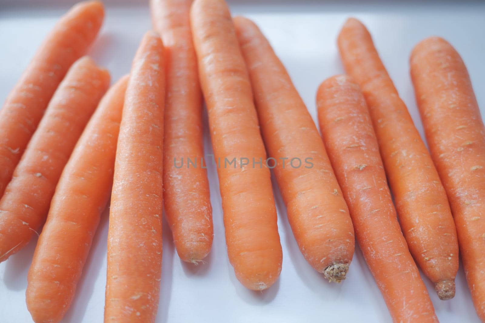 fresh carrots on chopping board on table .