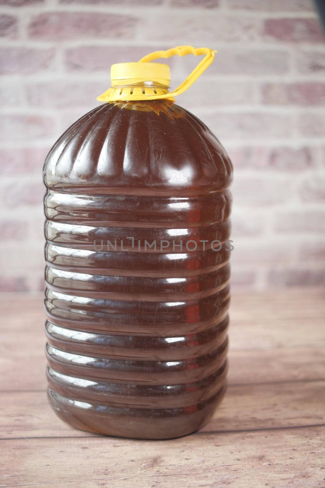 Mustard oil in a plastic jar on table . High quality 4k footage