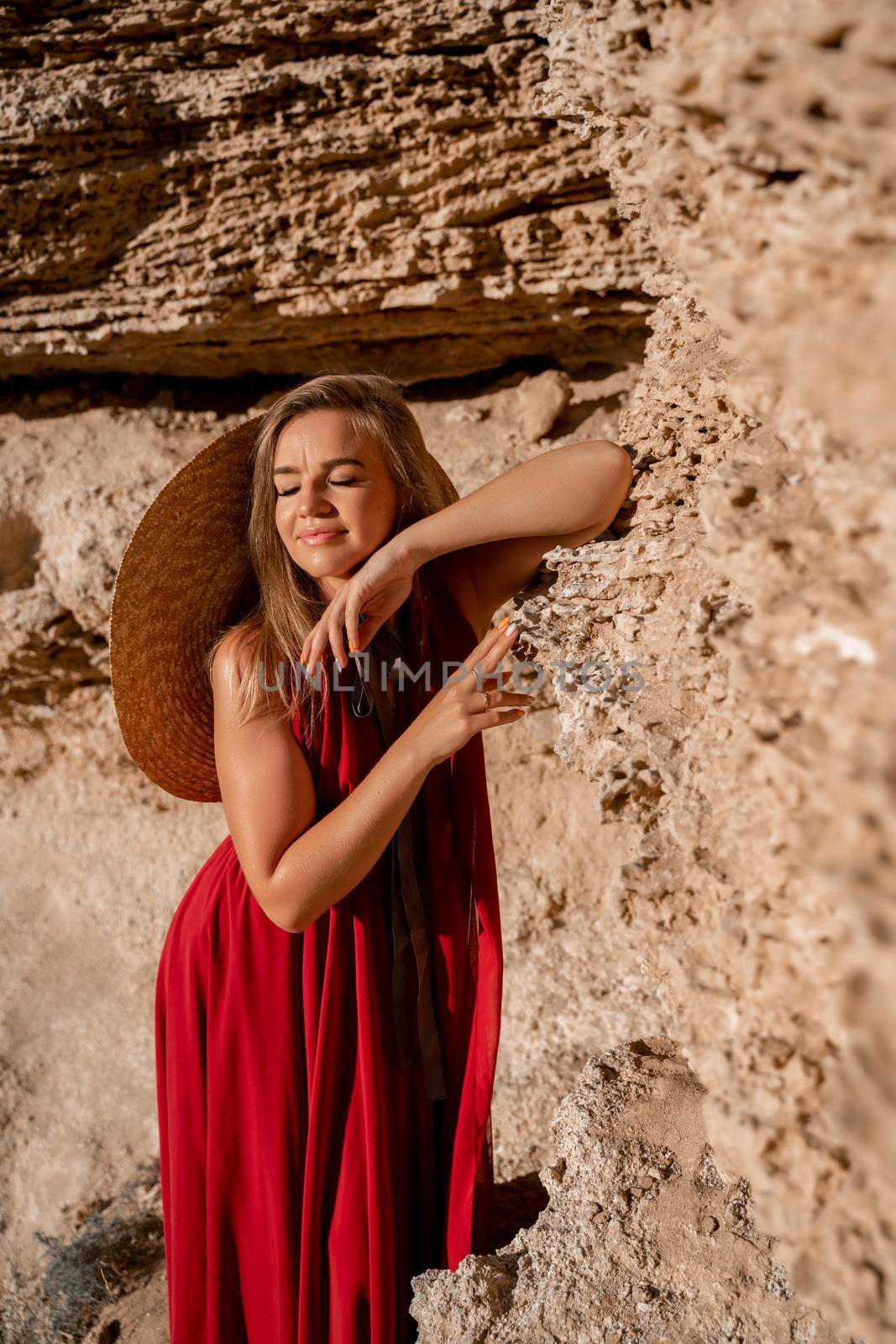 A woman in a red flying dress fluttering in the wind, against the backdrop of the sea