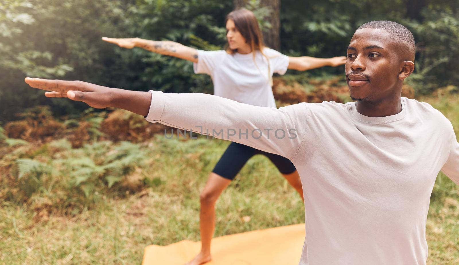 Couple, nature and yoga of a man and woman in workout exercise for the mind, body and spirit outdoors. Interracial fitness people together in relaxing exercises, stretching and balance lifestyle. by YuriArcurs