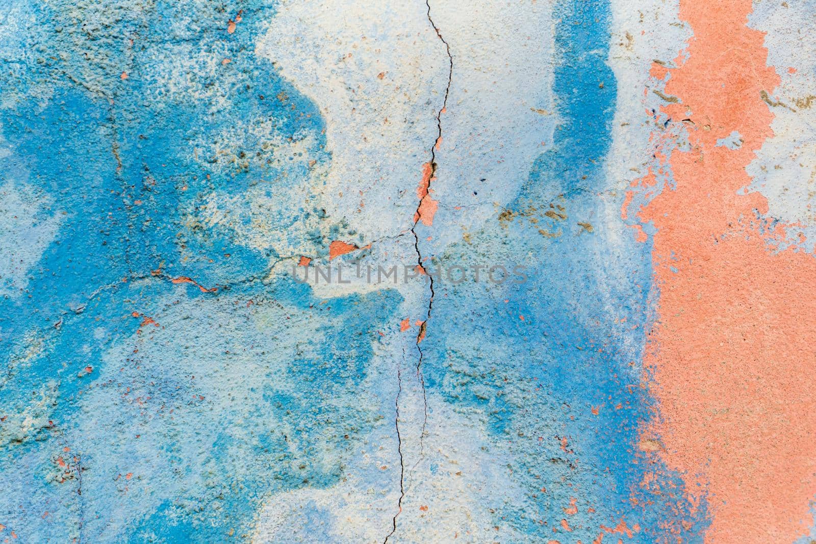 Old blue-pink wall covered with cracks background