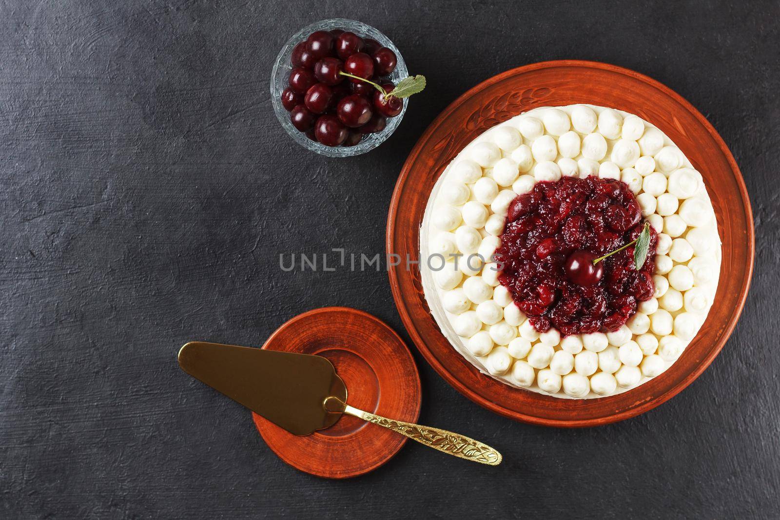 Biscuit cake, cherry souffle with cream cheese and cherry confiture on a black background. copy space