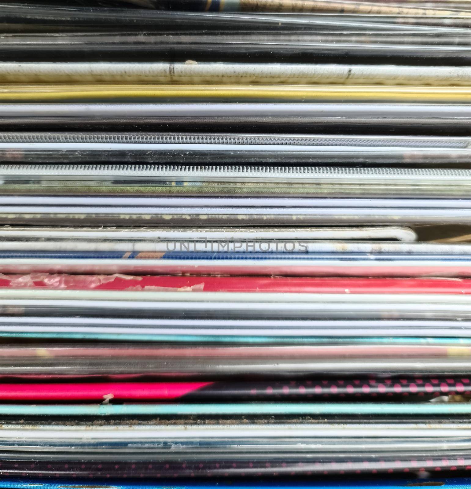 Numerous vintage signs and vinyl records in a box seen from above