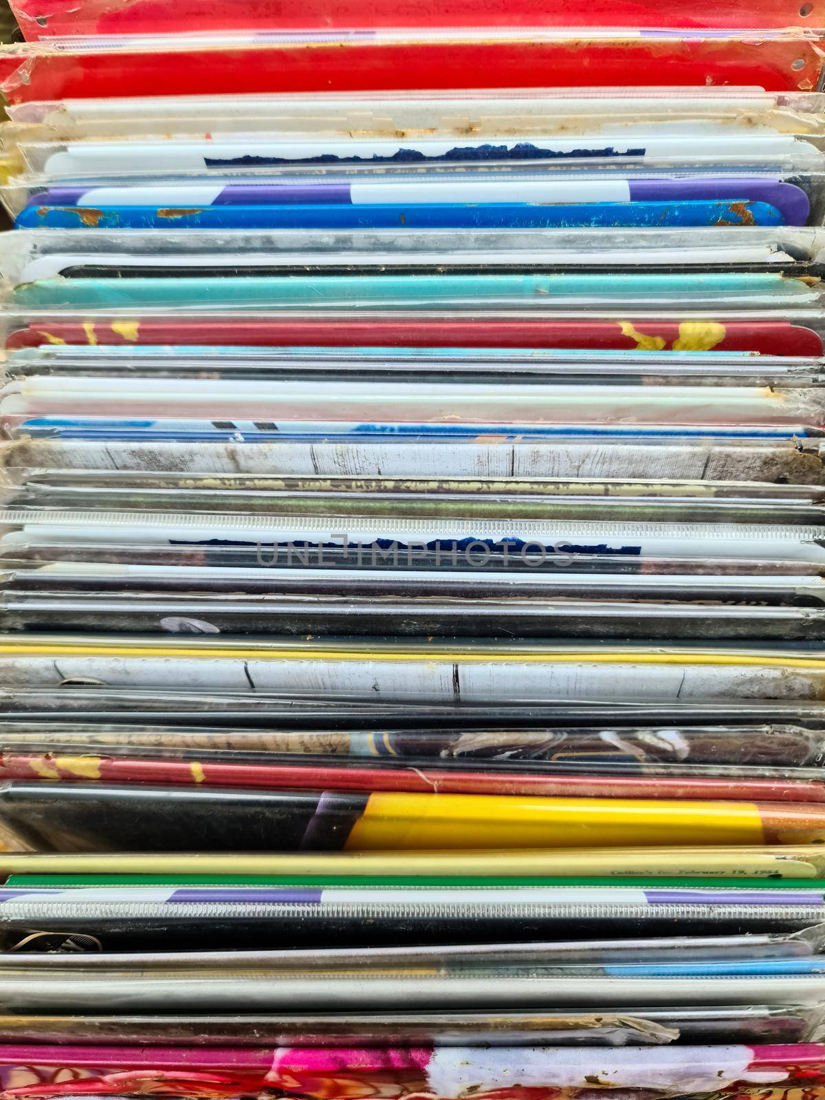 Numerous vintage signs and vinyl records in a box seen from above
