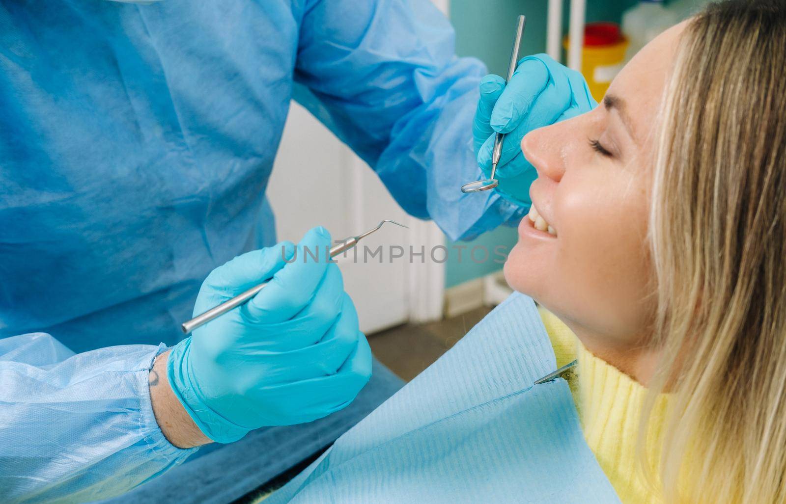 The patient treats her teeth at the dentist in the dental office . Dental fillings.