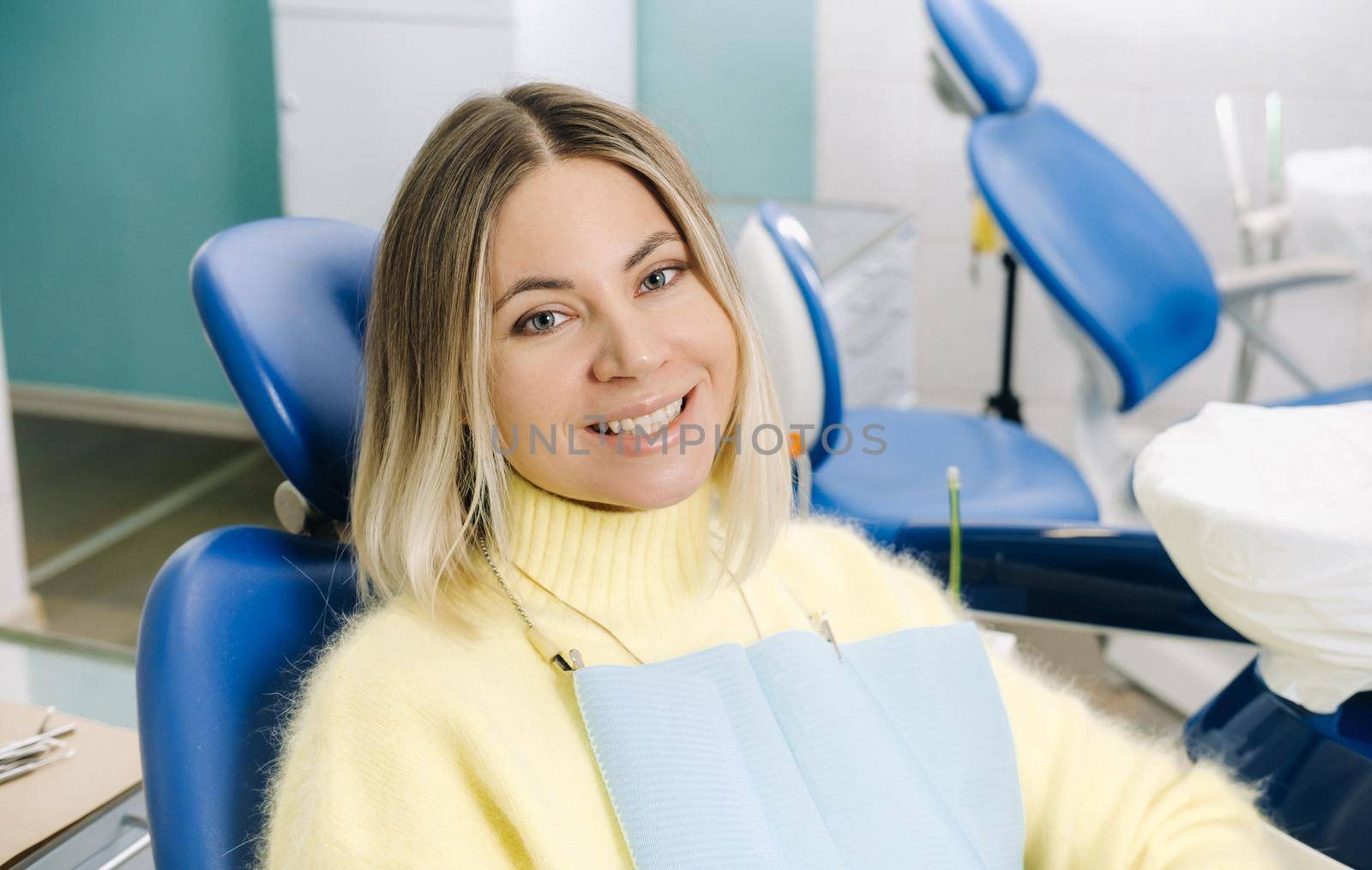 The girl smiles at the dentist and looks at her.