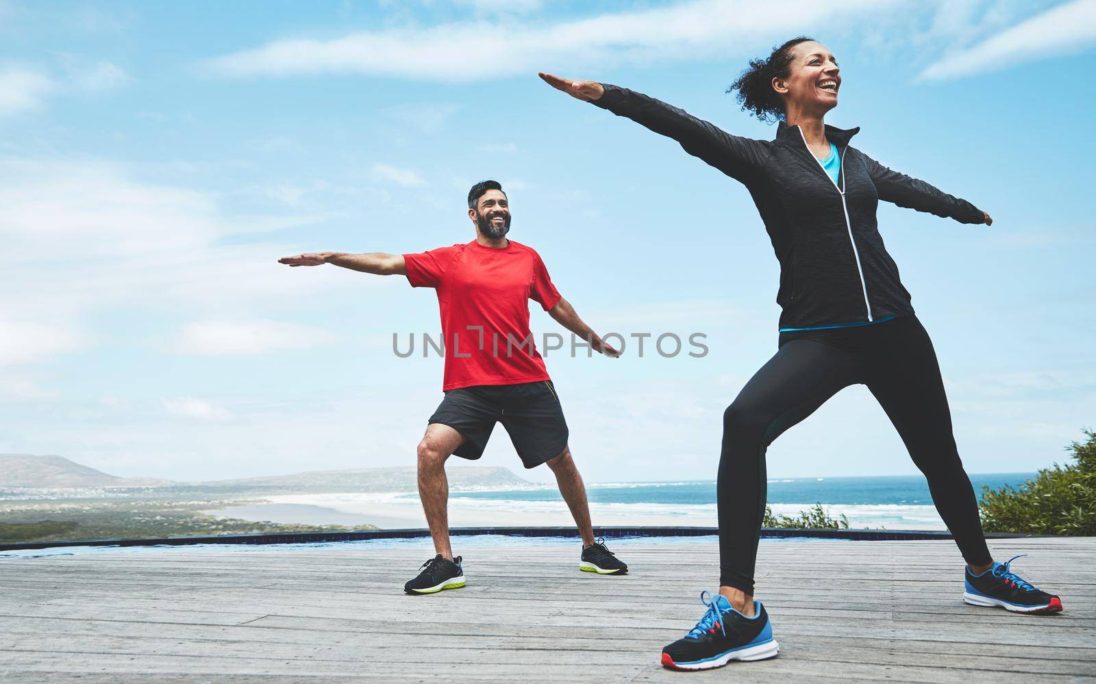 Nature connects us to our roots. a couple doing yoga outdoors. by YuriArcurs