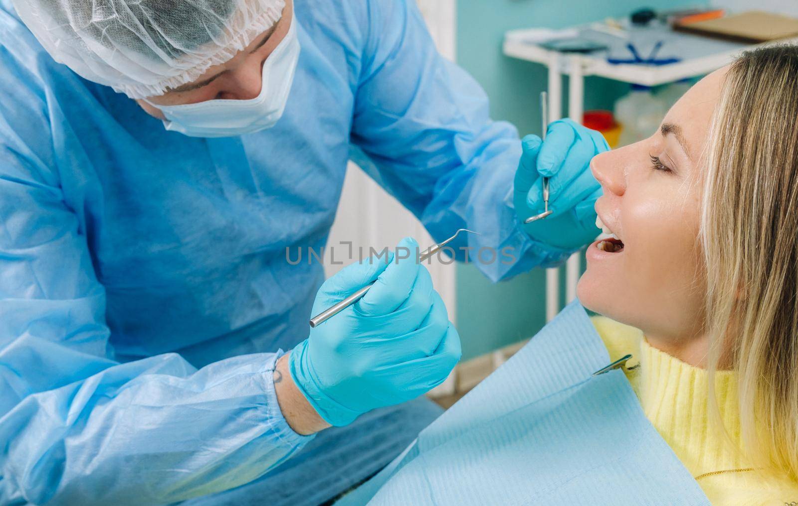 The patient treats her teeth at the dentist in the dental office . Dental fillings.