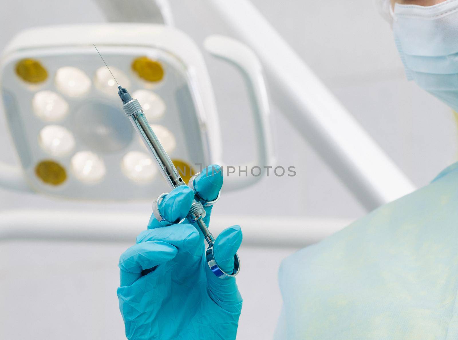 close-up of a dentist's hand holding an injection syringe for a patient in the office.