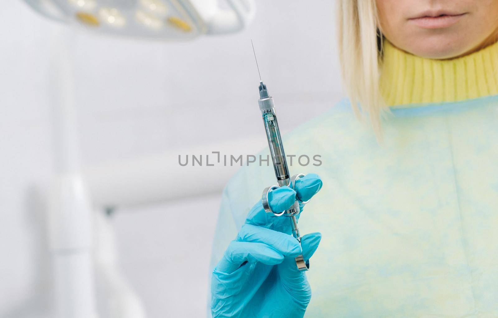 close-up of a dentist's hand holding an injection syringe for a patient in the office.