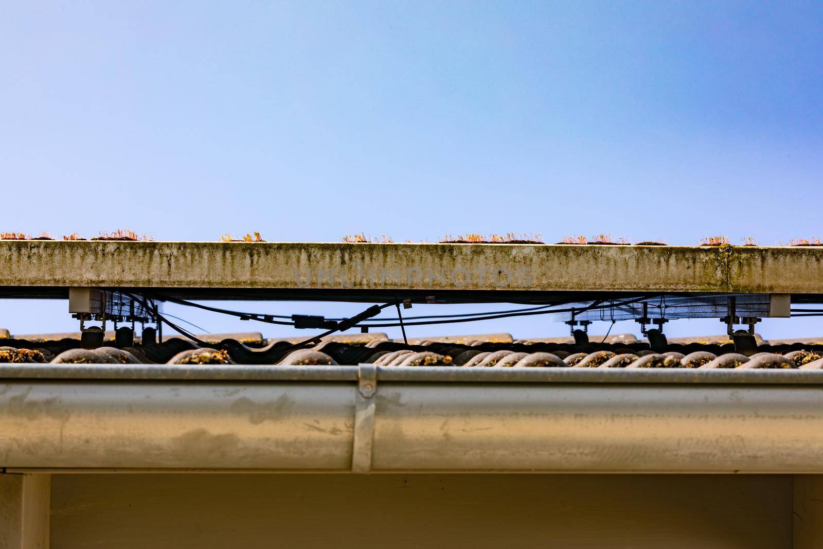 Solar modules of a photovoltaic system on a roof with the wiring underneath