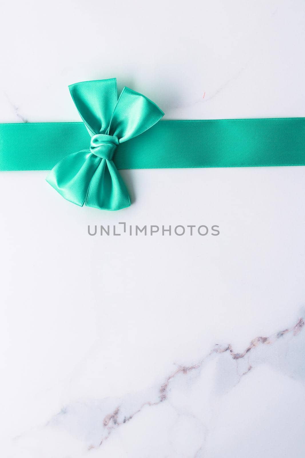 Green silk ribbon on marble background, top view by Anneleven